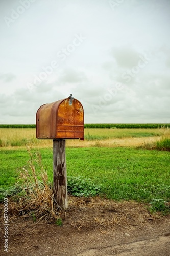 An old rusty mailbox in a field.