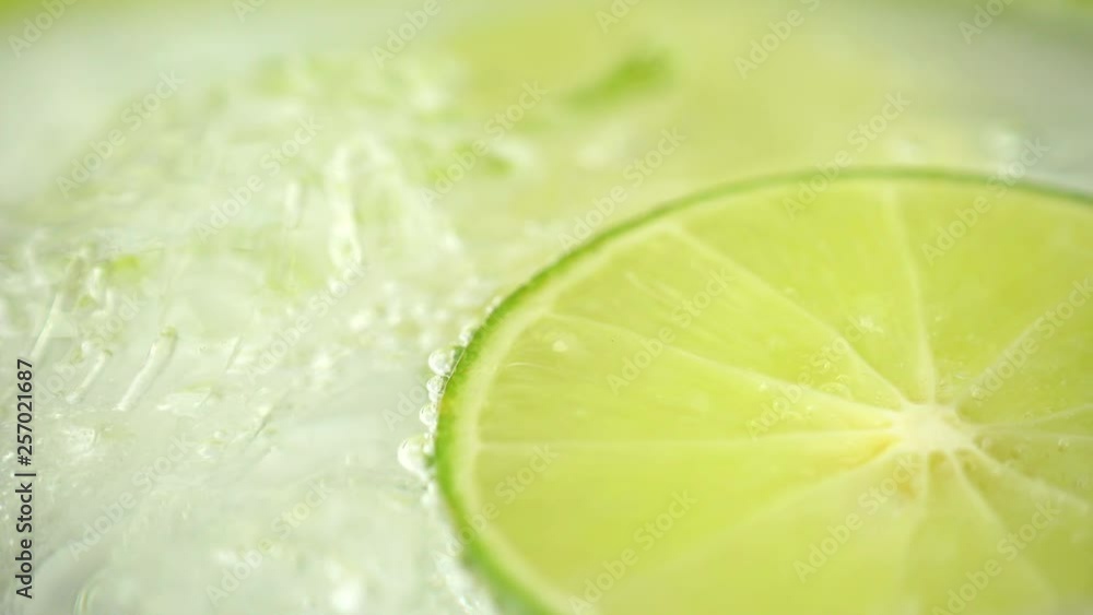 Close-up of a refreshing drink with bubbles interacting with ice and lime. Cold cocktail with lime. 4K resolution Close-up of a refreshing drink with bubbles interacting with ice and lime. Cold cocktail with lime. 4K resolution