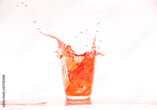 Red juice splash in glass isolated on white background