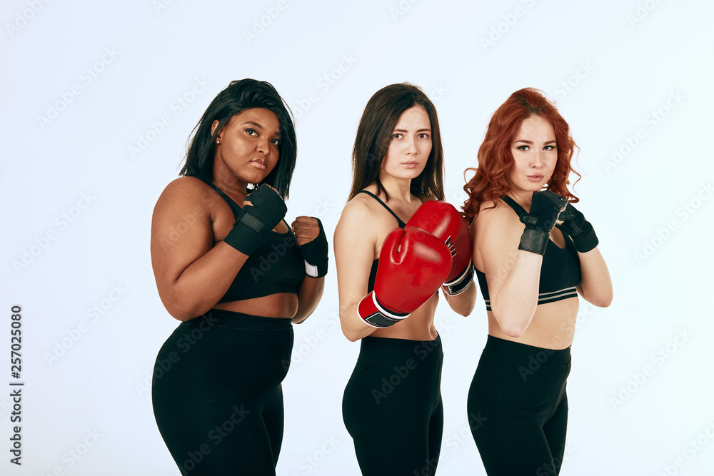 Three diverse multi ethnic sports female boxers with different skin colour  and complexion standing in fighting stance against white background Stock  Photo | Adobe Stock