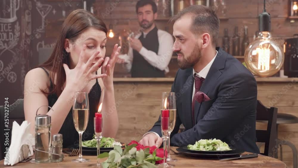 Angry girlfriend finds out her boyfriend is cheating and slaps him at a romantic date. A couple breaking up. Young woman leaving the date dissapointed. Angry girlfriend finds out her boyfriend is cheating and slaps him at a romantic date. A couple breaking up. Young woman leaving the date dissapointed.