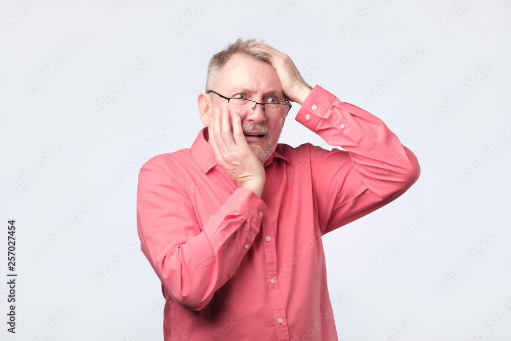 Senior man in red shirt suffering from tooth pain. Senior man in red shirt suffering from tooth pain.