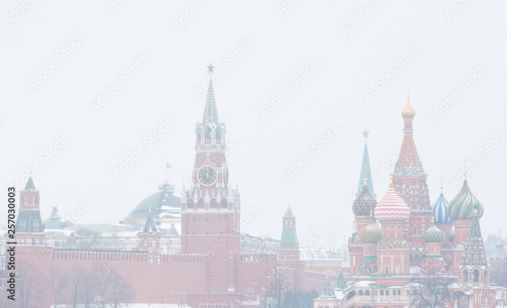 Winter day. Heavy snowfall. Blizzard. Spasskaya Tower of Moscow Kremlin and the Cathedral of Vasily the Blessed (Saint Basil's Cathedral) on Red Square. Moscow. Russia