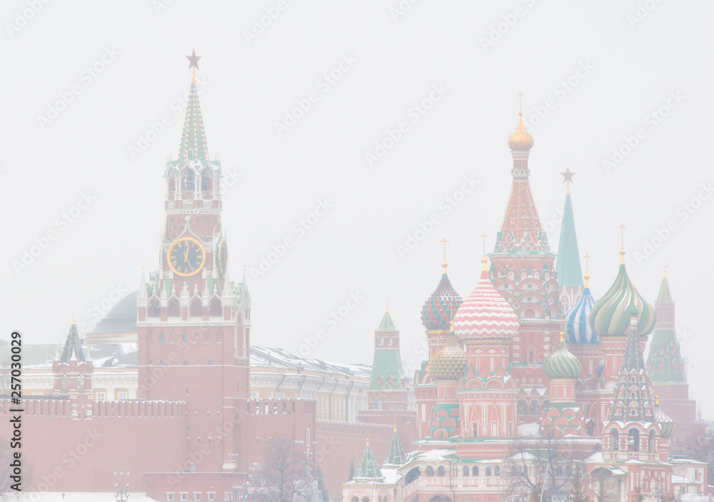 Winter day. Heavy snowfall. Blizzard. Spasskaya Tower of Moscow Kremlin and the Cathedral of Vasily the Blessed (Saint Basil's Cathedral) on Red Square. Moscow. Russia