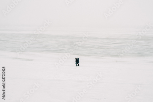 People on the frozen river. Walk a pair of lovers on the ice