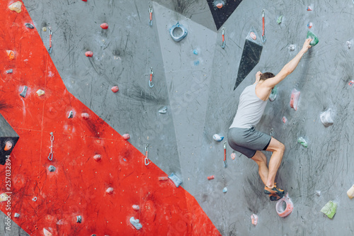 Athletic man climbing the wall. Active sport. Climbing gym.