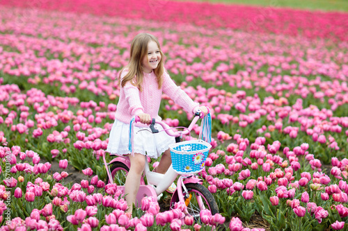 Canvas Print Child on bike in tulip field. Bicycle in Holland.