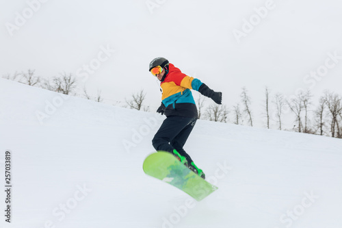 ambitious guy jumping with a snowboard, full length photo. sporty life, lifestyle, hobby