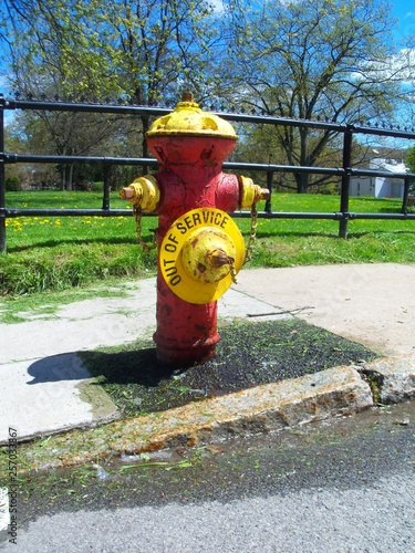 Out of Service dripping colorful old fire hydrant near a park