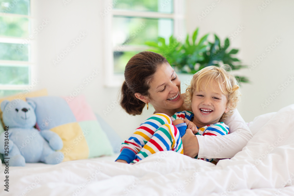 Mother and child in bed. Mom and baby at home.