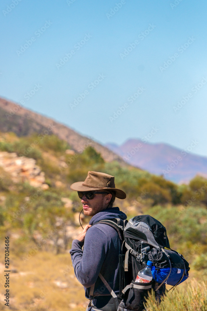 man enjoying view after a hike to the top of Mount Sonder just outside Alice Springs, West MacDonnel National Park, Australia
