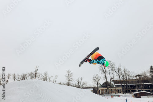 freestyle snowboarding concept, young man showing a stun. full length photo.copy space, risky kind of sport