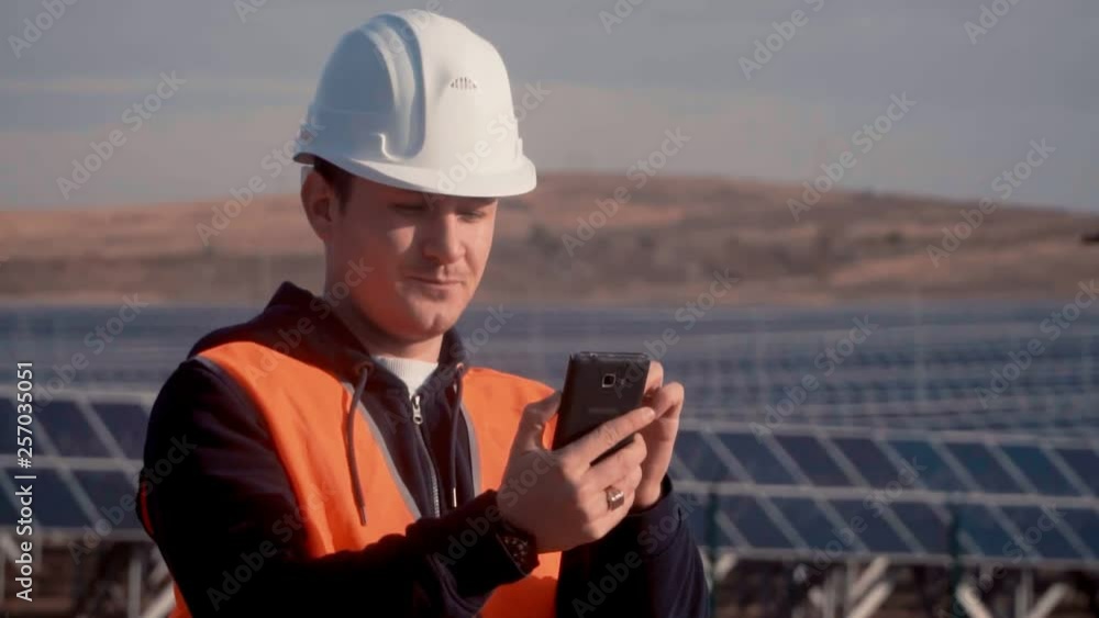 engineer in an orange vest via phone, reported to his superiors about the status of the solar panels on the enterprise engineer in an orange vest via phone, reported to his superiors about the status of the solar panels on the enterprise