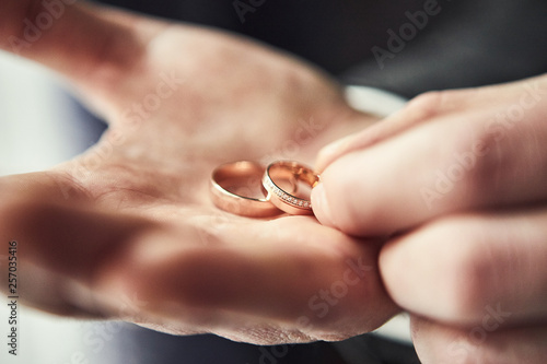 man holding wedding rings, groom getting ready in the morning before ceremony