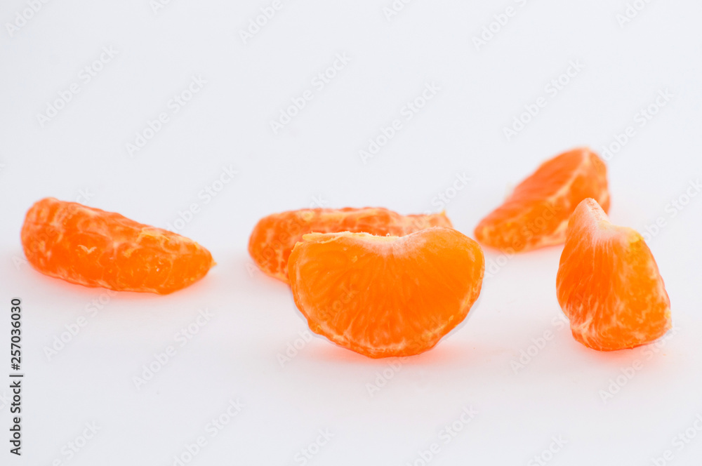 Mandarin slices on a white background, macro, space for copy Mandarin slices on a white background, macro, space for copy
