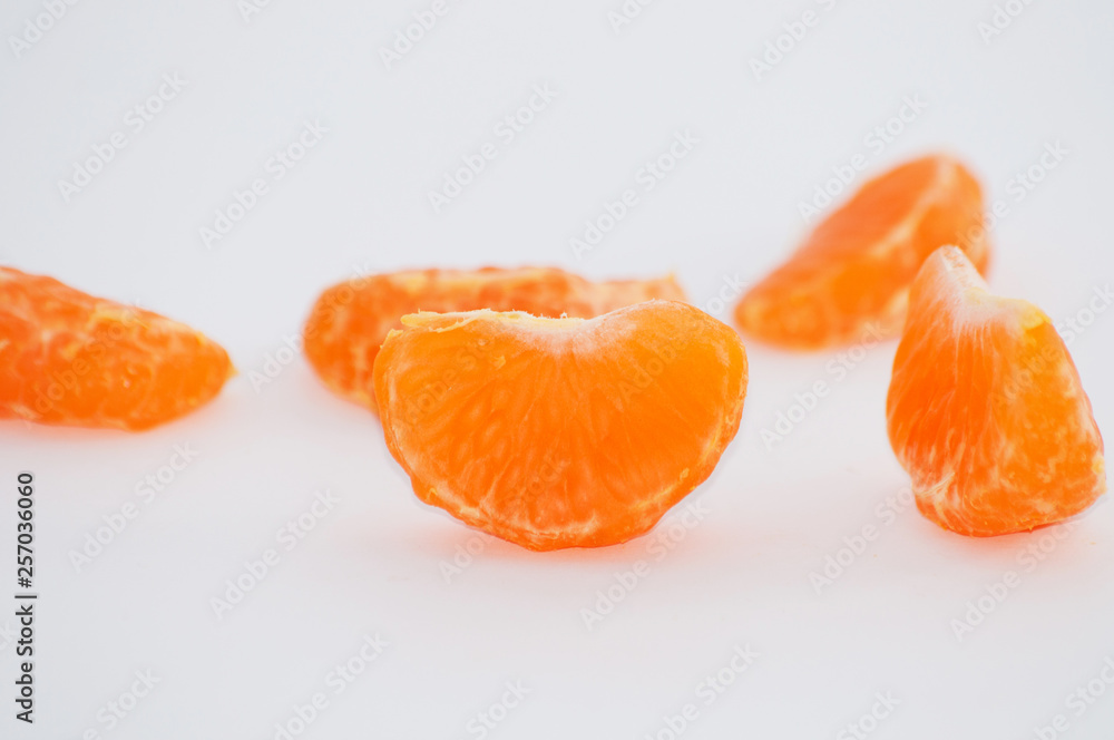 Mandarin slices on a white background, macro, space for copy Mandarin slices on a white background, macro, space for copy