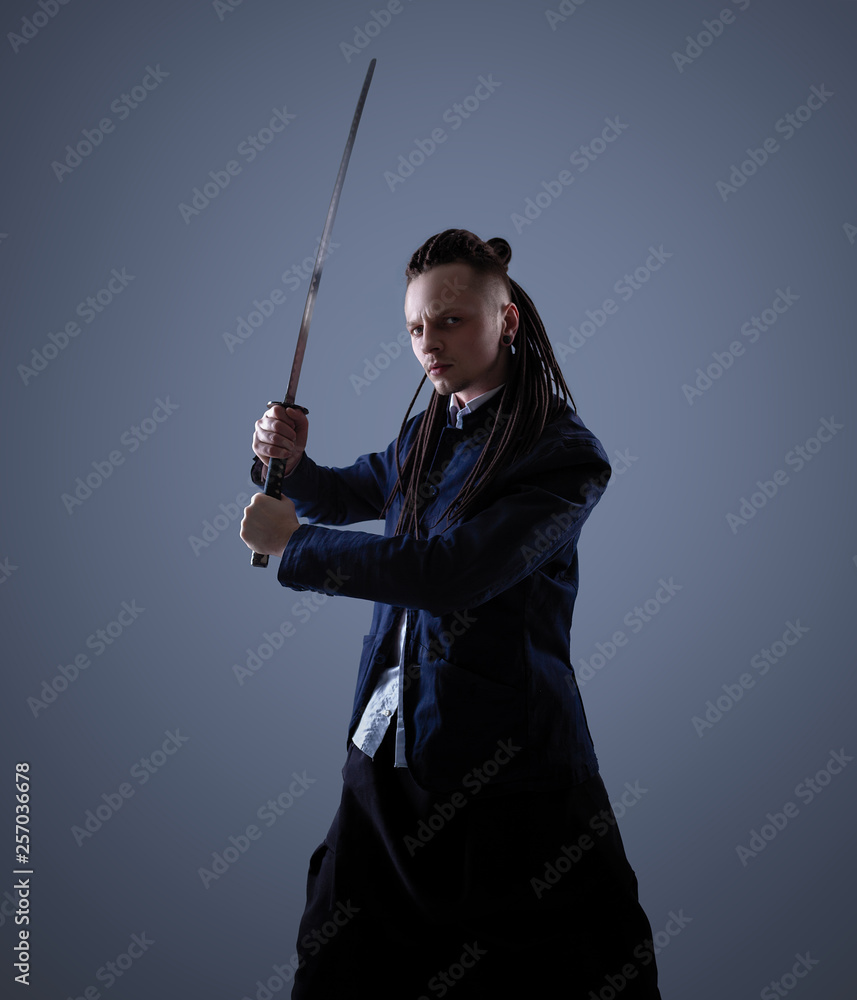 Young man holding a samurai sword. Glamour photo. Young man holding a samurai sword. Glamour photo.
