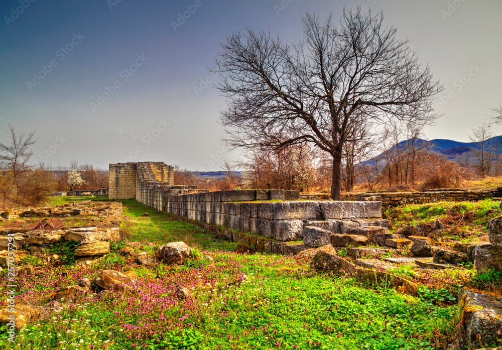 Solid stone wall and ruins of ancient fortress
