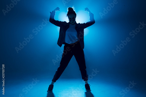 Stylish woman dancing solo on hip hop party. Sunglasses, modern black dance wear, neon lights. © alfa27