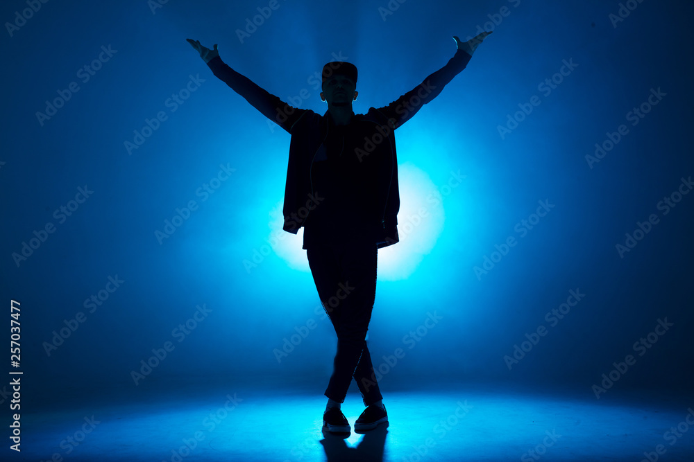 Leisure, lifestyle, hobby and sport. Professional male dancer dancing in night club with smoke and blue neon lights with flare in centre