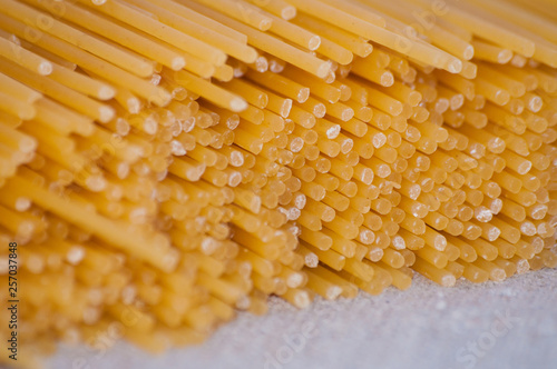 Raw spaghetti on a gray background close-up top view side macro