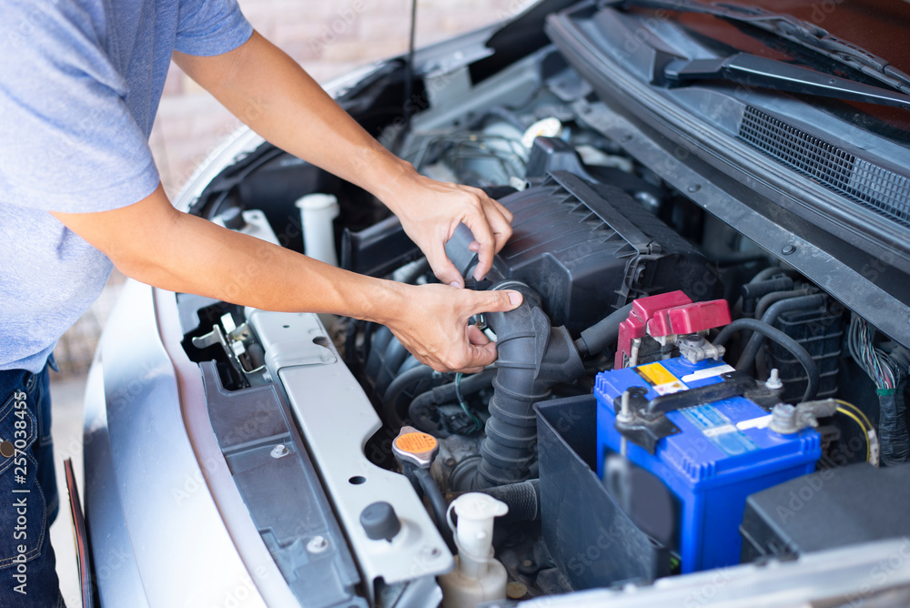 Fototapeta premium Inżynier samochodowy dba o filtr silnika w garażu.