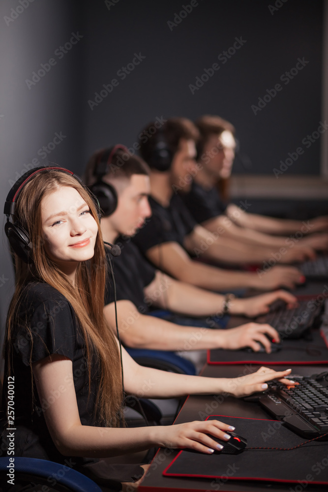 Team of professional eSport gamers with a cute young woman in focus ...