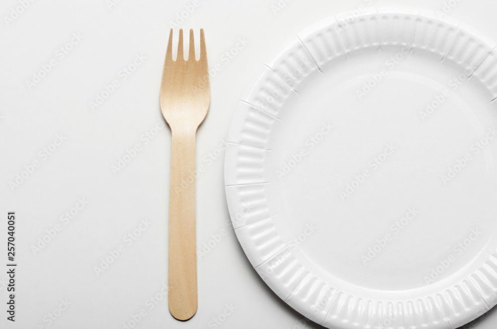 Wooden single use kitchenware and paper plate on white background simple view Wooden single use kitchenware and paper plate on white background simple view