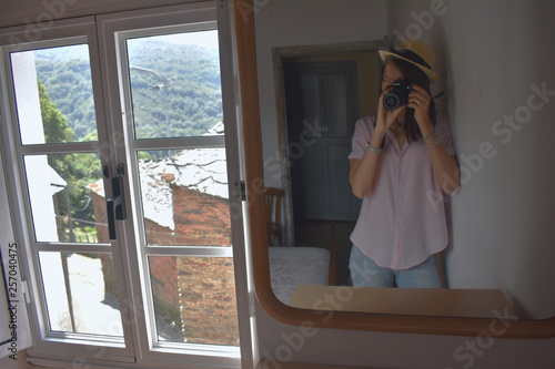 Chica haciendo foto al espejo, ventana antigua, paisaje, montaña photo