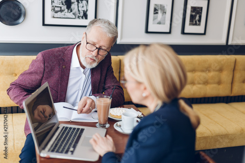 businessman and businesswoman analyzing the document during the coffee break. close up photo