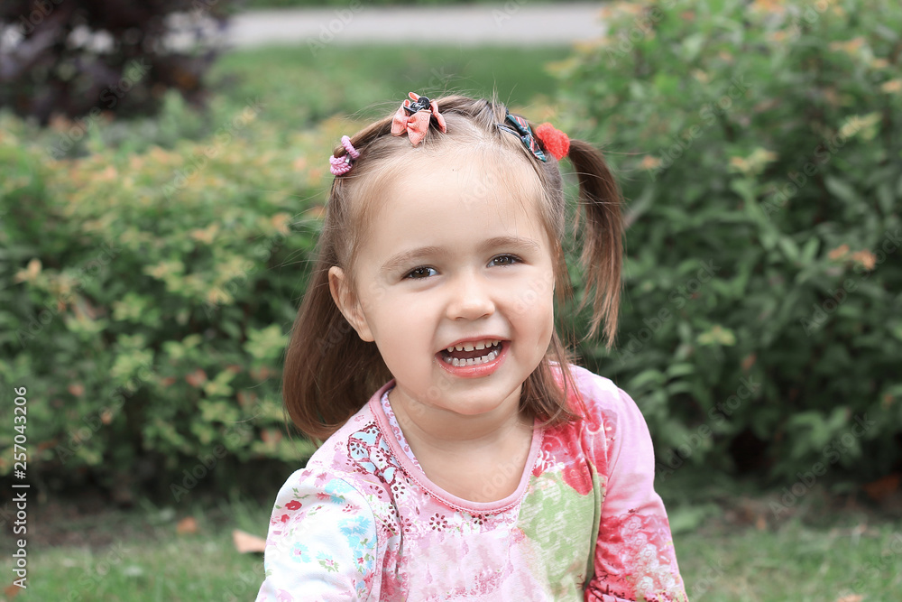 happy little girl sitting on the lawn on a summer day happy little girl sitting on the lawn on a summer day