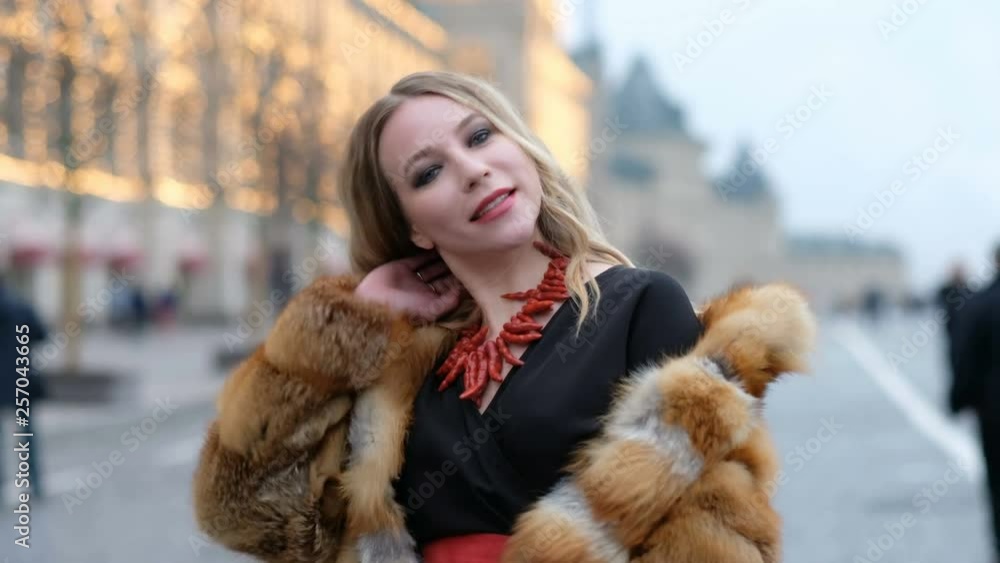Attractive happy glamorous woman in fox fur coat, outdoors Attractive happy glamorous woman in fox fur coat, outdoors