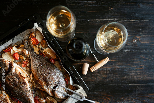 Obraz na płótnie dinner concept for two. two glasses of white wine, baked fish. w salonie