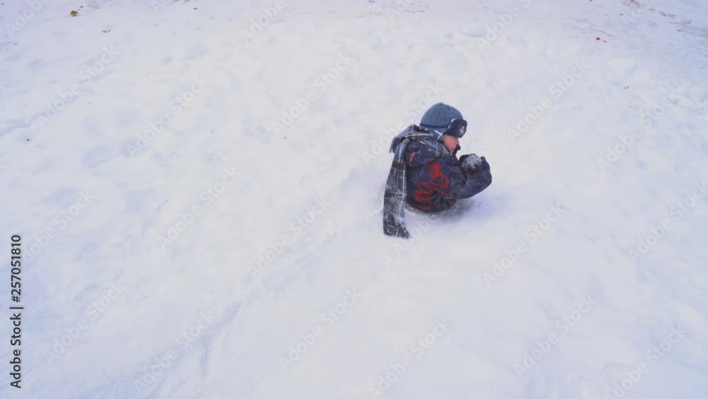 A boy and a girl riding a roller coaster. Children's game. Winter season. Warm clothing. White snow. Tall tree. A walk in the Park. A boy and a girl riding a roller coaster. Children's game. Winter season. Warm clothing. White snow. Tall tree. A walk in the Park.