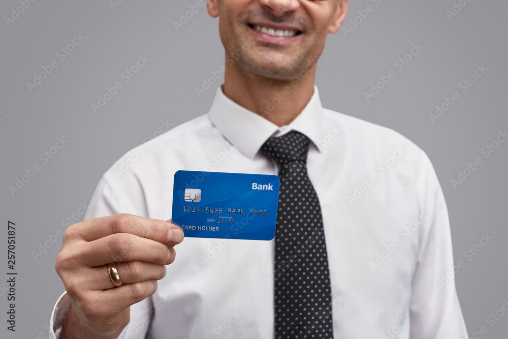 Crop businessman demonstrating plastic card 