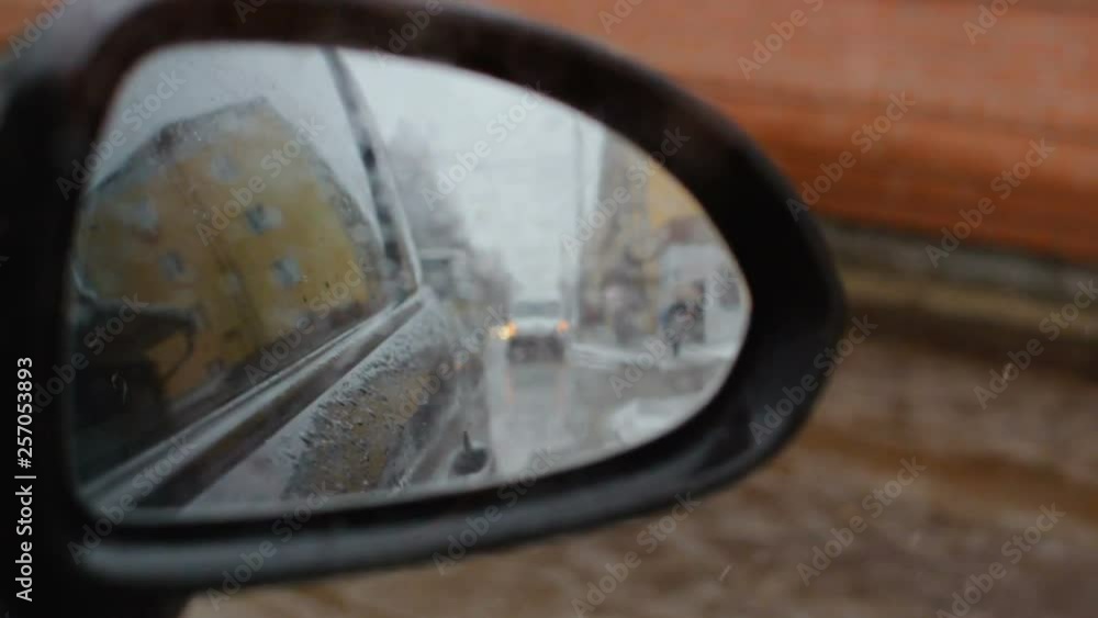side mirror of the car. Reflection rear view. Humidity and slush on the street, sleet. Bad weather conditions side mirror of the car. Reflection rear view. Humidity and slush on the street, sleet. Bad weather conditions