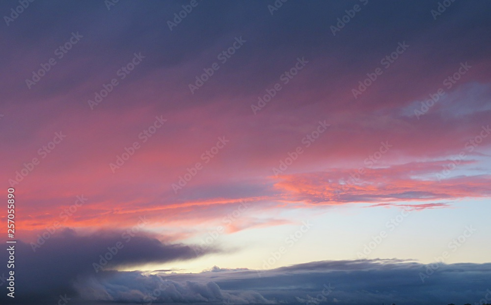 Beautiful fiery pink burgundy sunset background in the sky
