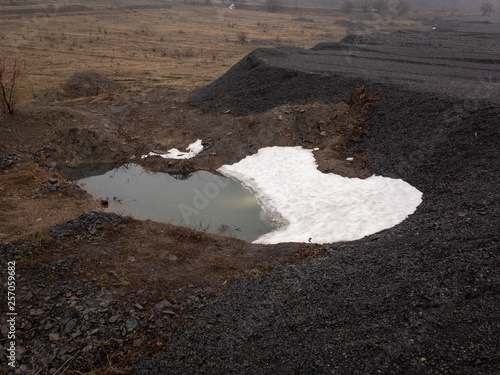 Black charcoal mountain and lake under snow