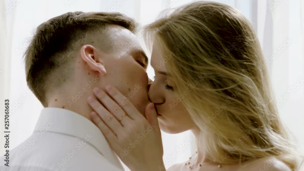 Close-up shot of attractive young happy woman and smiling handsome man tenderly kissing each other. 4K Close-up shot of attractive young happy woman and smiling handsome man tenderly kissing each other. 4K