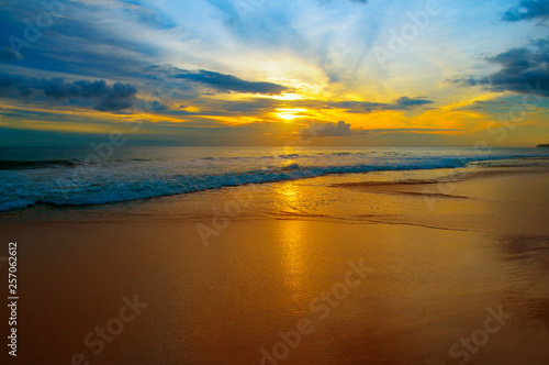 Beach of the ocean and bright sunrise .