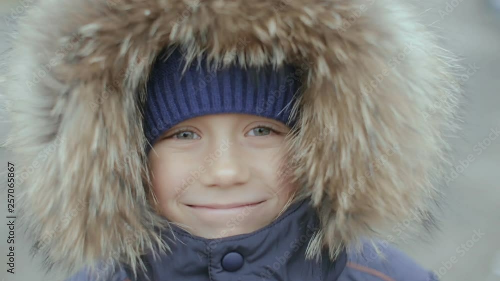 Portrait of a boy in winter jacket with hood on his head Portrait of a boy in winter jacket with hood on his head