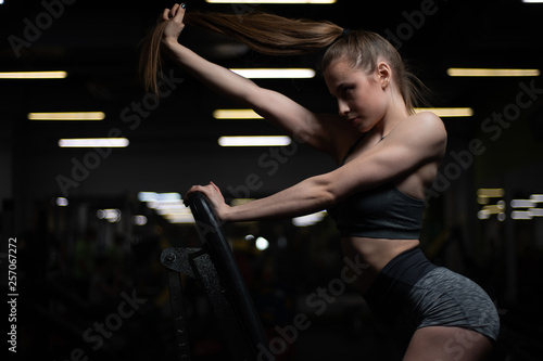 Fitness girl posing in the gym on the bench showing off her body