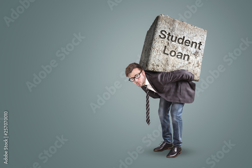 Concept of a man in a suit bending under the burden of a student loan photo