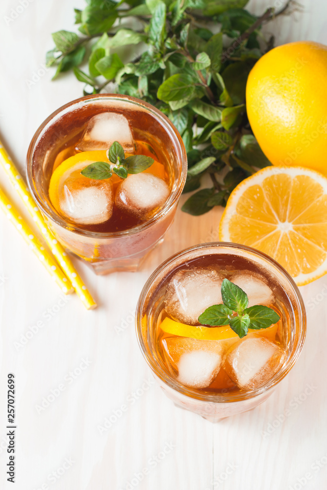 Refreshing citrus lemonade, summer drink. Ice tea with fresh lemon and mint on wooden background. Refreshment beverage concept. Refreshing citrus lemonade, summer drink. Ice tea with fresh lemon and mint on wooden background. Refreshment beverage concept.