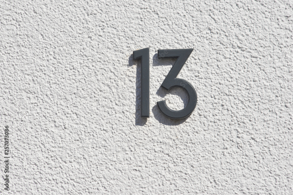 Hausnummer 13 aus beschichtetem Metall an einer weiss verputzten Hauswand  Stock Photo | Adobe Stock
