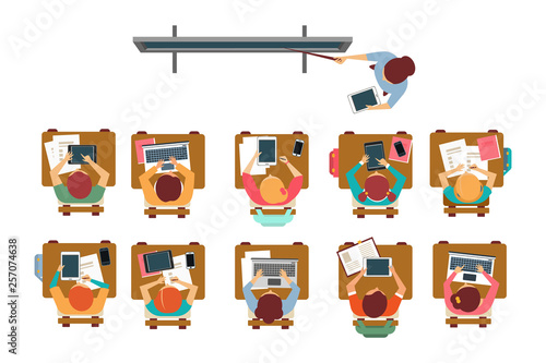 Kids sitting at the desks in classroom, teacher standing and pointing at the blackboard top view vector illustration