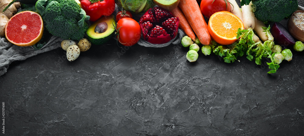 Organic food on a black stone background. Vegetables and fruits. Top view. Free copy space. Organic food on a black stone background. Vegetables and fruits. Top view. Free copy space.