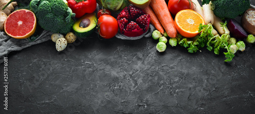 Organic food on a black stone background. Vegetables and fruits. Top view. Free copy space.