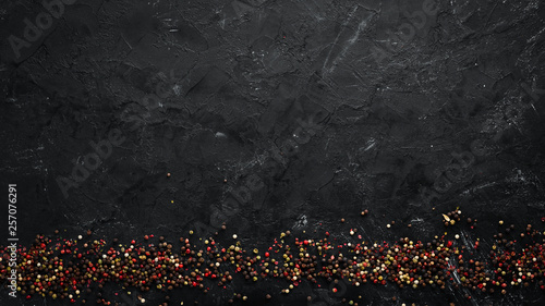 Peppers and spices on a black background. Top view. Free space for your text. Rustic style.