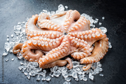 Fresh catched octopus offered as closeup on crushed ice at a display counter